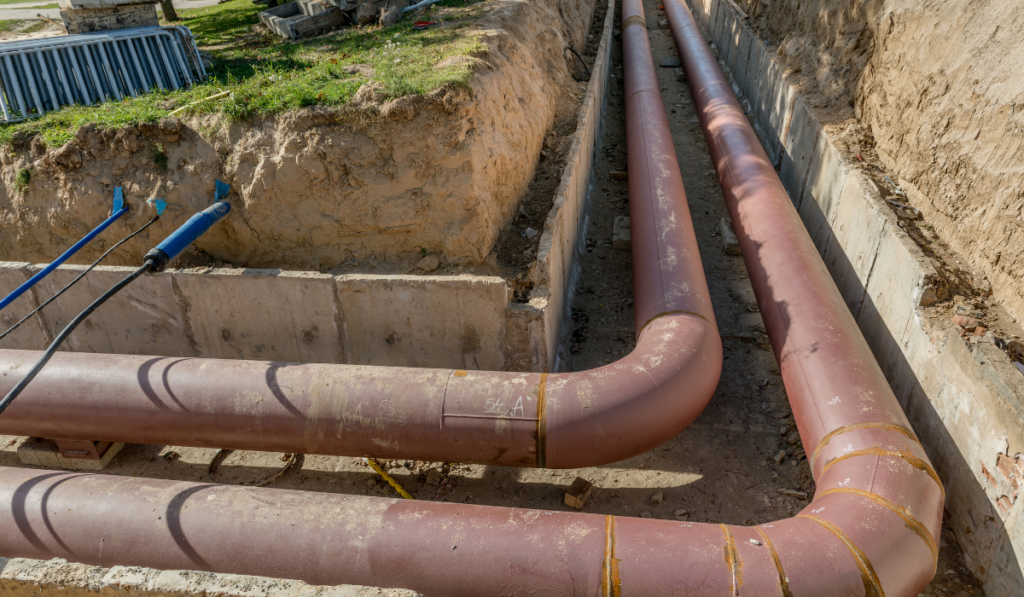 Multiple underground utility pipes including sewer and conduit lines installed in open trench before backfill during utility installation project in Bradenton FL