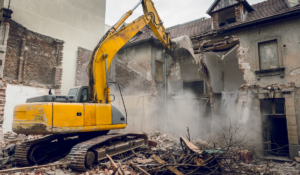 Yellow excavator demolishing a structure on a Sarasota County demolition contractor project in Nokomis FL