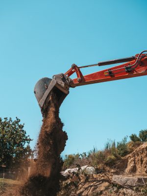 Closeup of a backhoe with dirt against sky building demolition contractors parrish